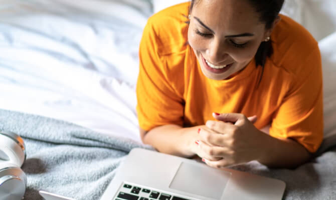 Femme souriante regardant un ordinateur portable